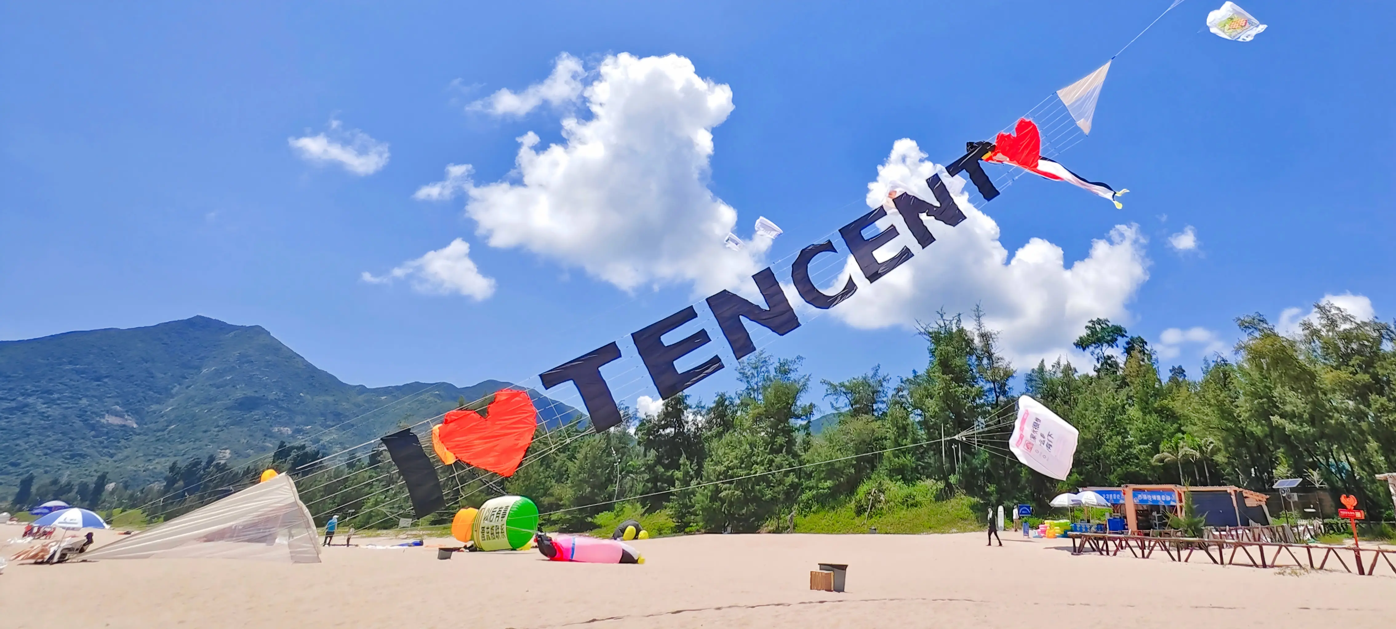 I love Tencent display above a beach and mountain landscape